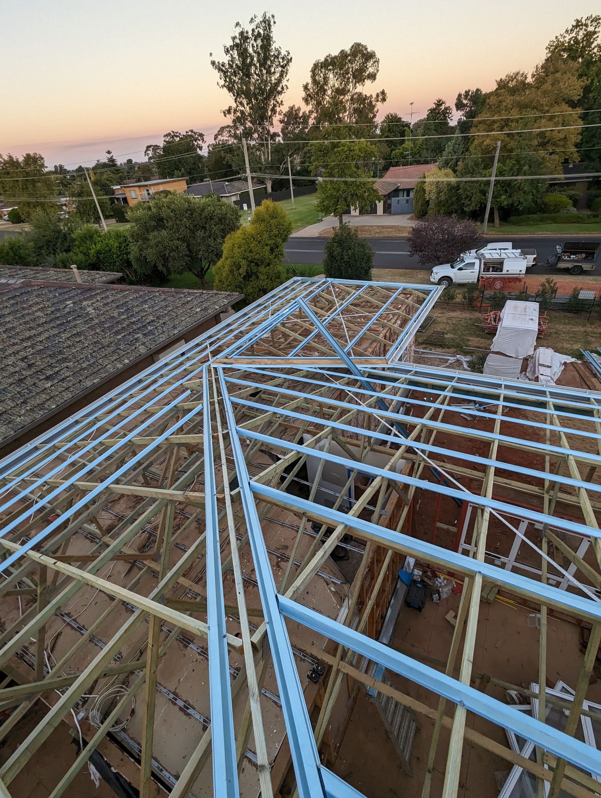 Wooden Roof Trusses Under Construction Against a Blue Sky — CJ Custom Carpentry in Port Macquarie, NSW