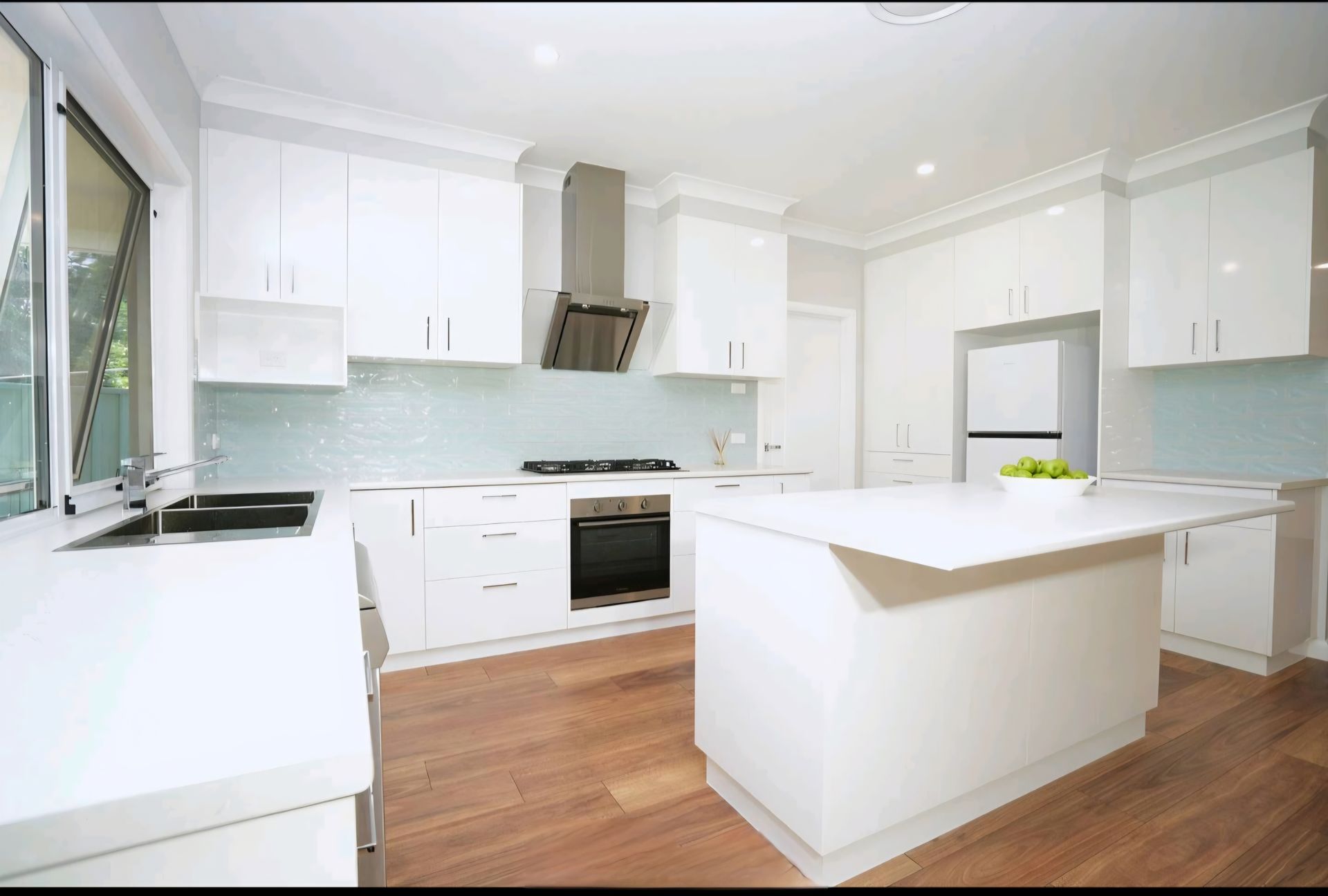 Modern Kitchen With White Cabinets, Island, and Dark Wood Floors — CJ Custom Carpentry in Port Macquarie, NSW