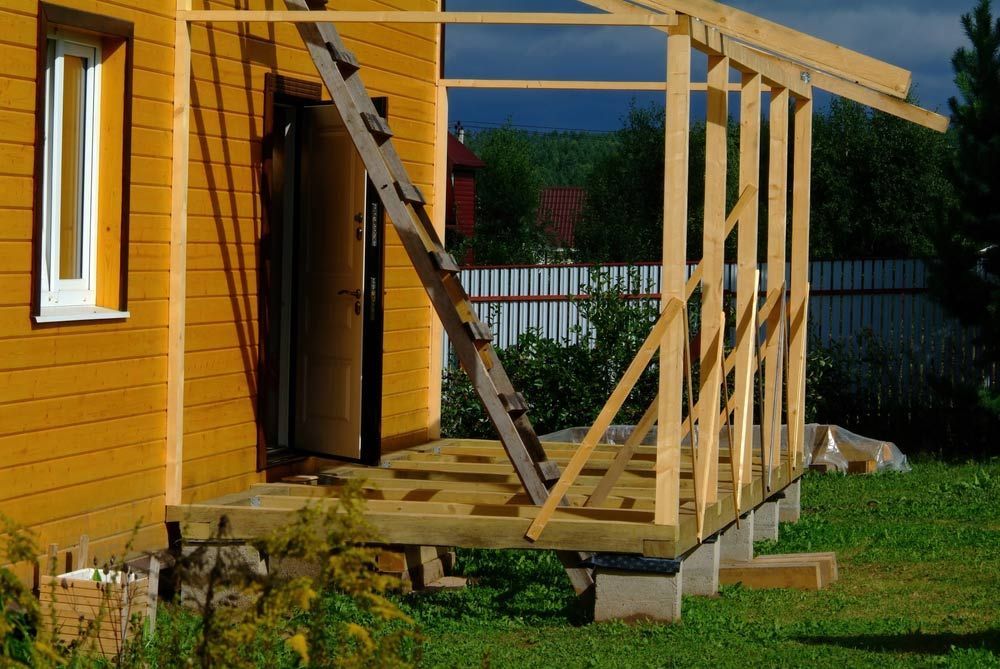 Wooden Porch Under Construction Next to a Yellow House — CJ Custom Carpentry in Wauchope, NSW
