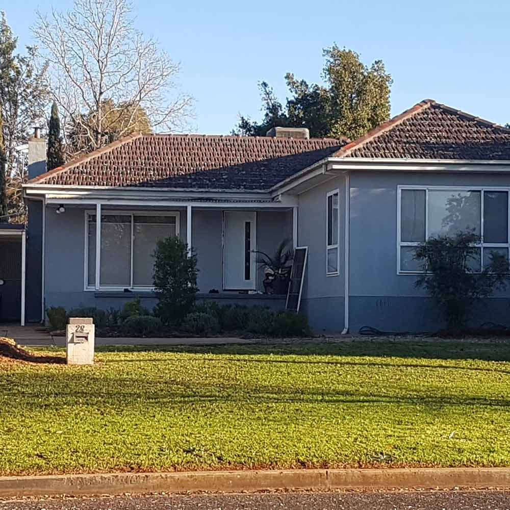 Gray House With Brown Tile Roof, White Trim, and Green Lawn on a Sunny Day — CJ Custom Carpentry in Port Macquarie, NSW