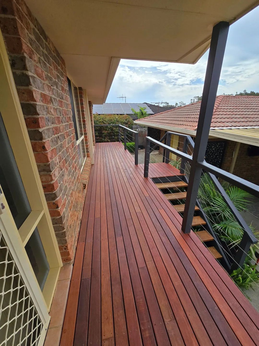 Patio With Chairs on Wooden Deck, Glass Doors to Interior — CJ Custom Carpentry in Port Macquarie, NSW
