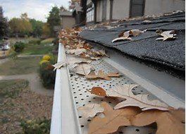 Home Gutters — Residential Gutter with Fallen Leaves in Fort Wayne, IN