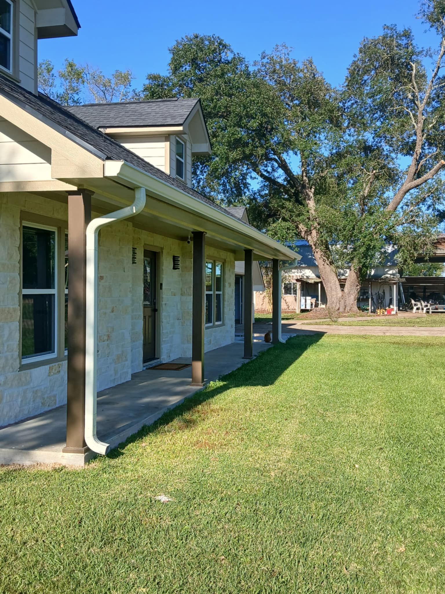 Aerial view of a large house with a swimming pool, spa, and multiple dark roofs.