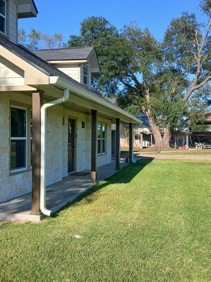 Aerial view of a large house with a swimming pool, spa, and multiple dark roofs.