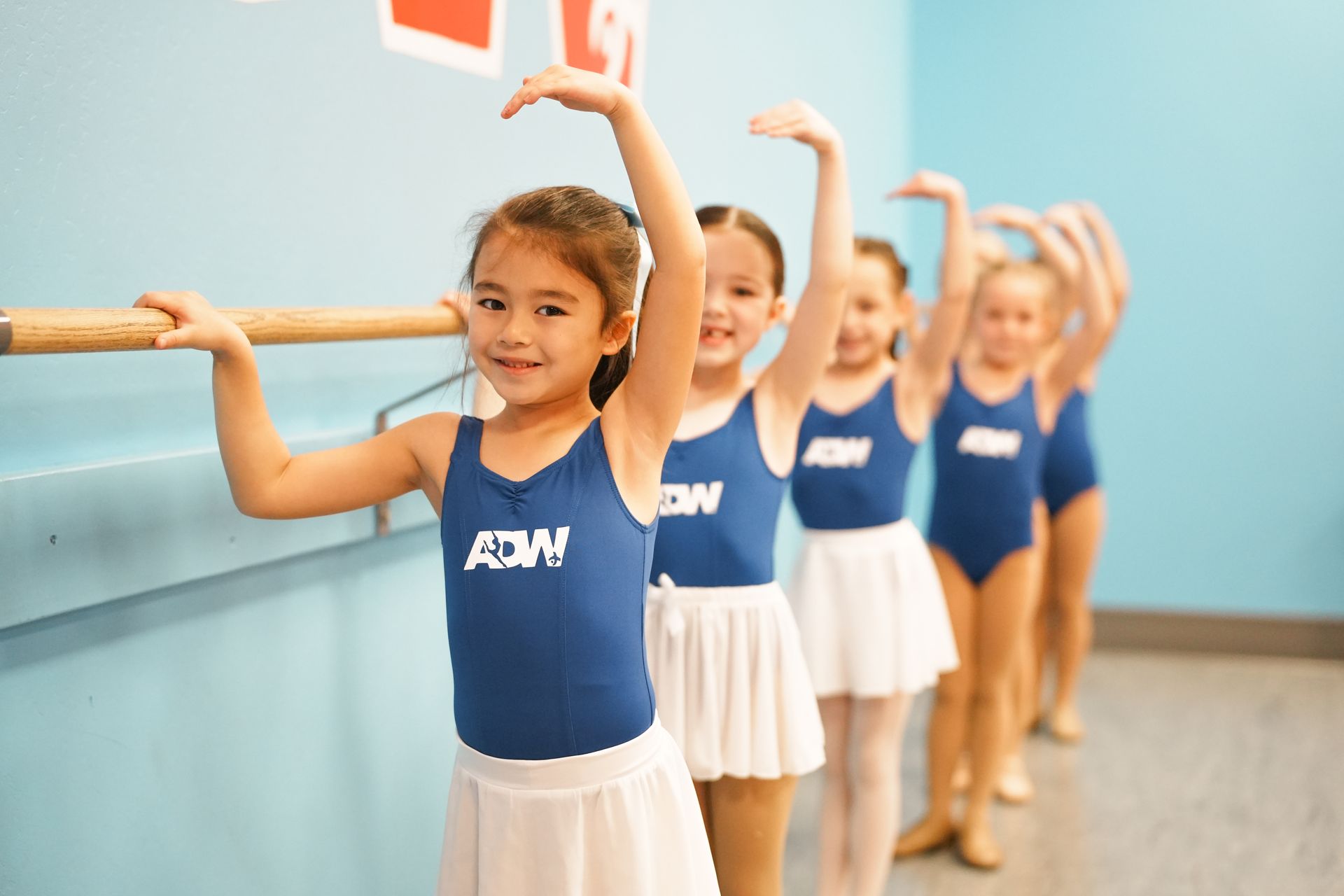 A little girl in a pink dress is dancing