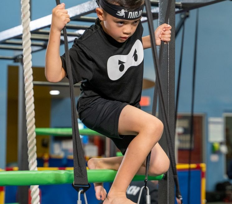A young boy wearing a black shirt that says ninja on it