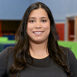 A woman in a black shirt is smiling for the camera.