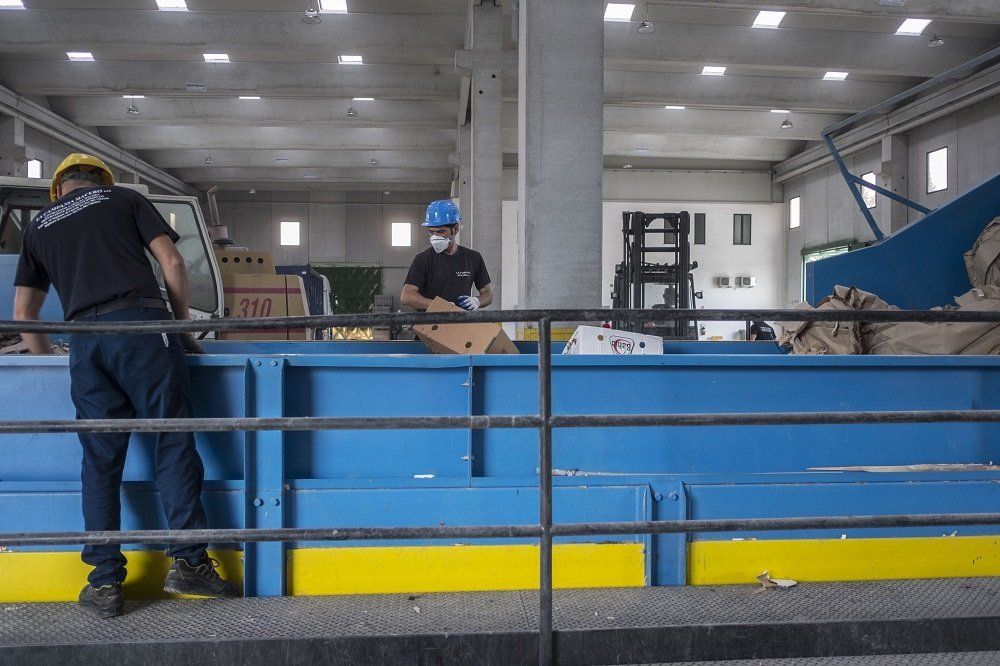 operai vicino un compattatore