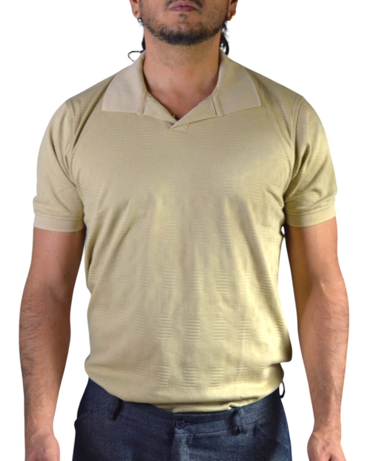 Hombre vestido con un polo blanco, de pie sobre un fondo blanco.