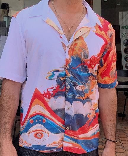 Un hombre que lleva una camisa blanca con un diseño colorido.