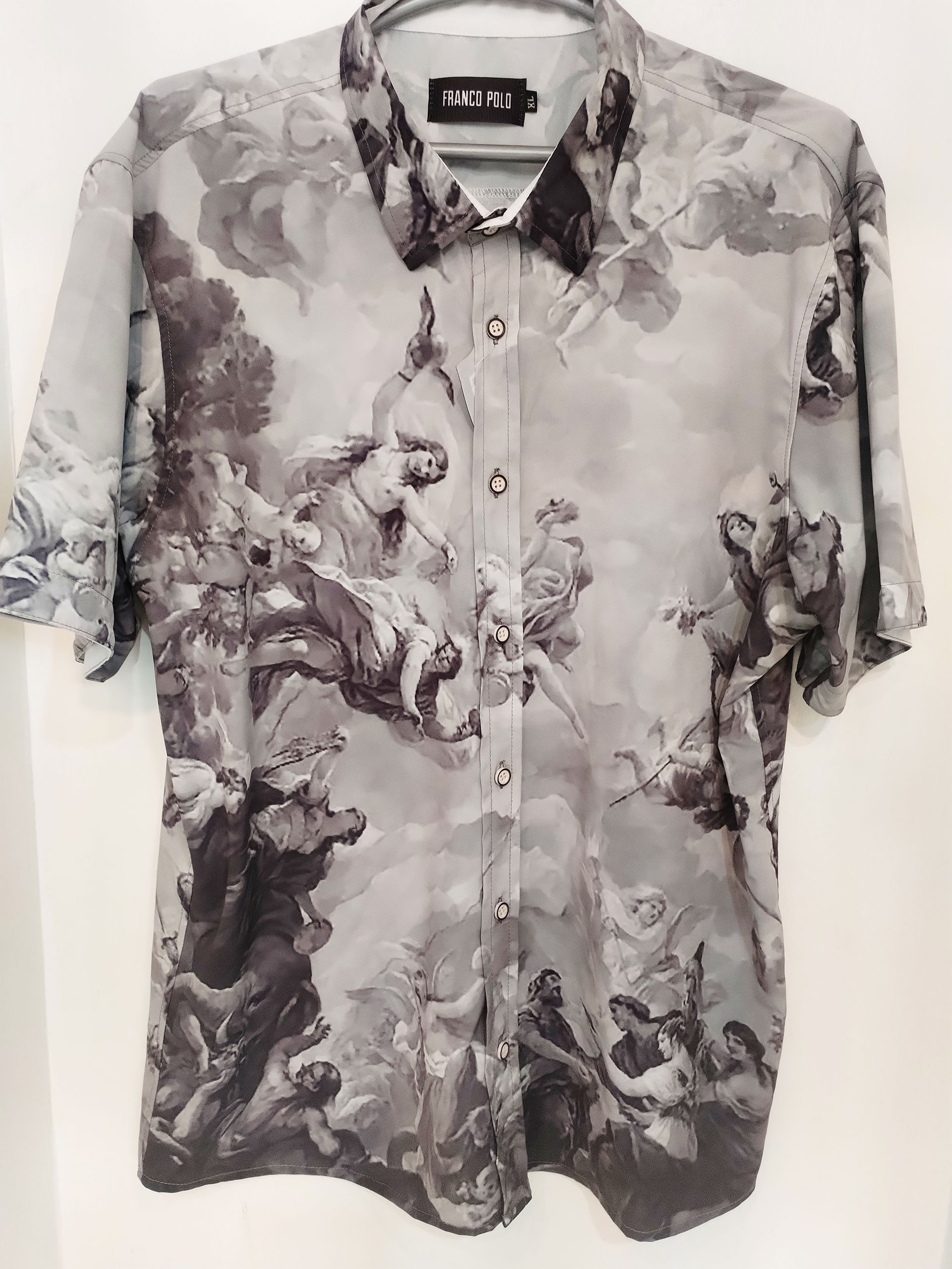 Camisa de manga corta con botones y mangas dobladas, estampada en blanco y negro.