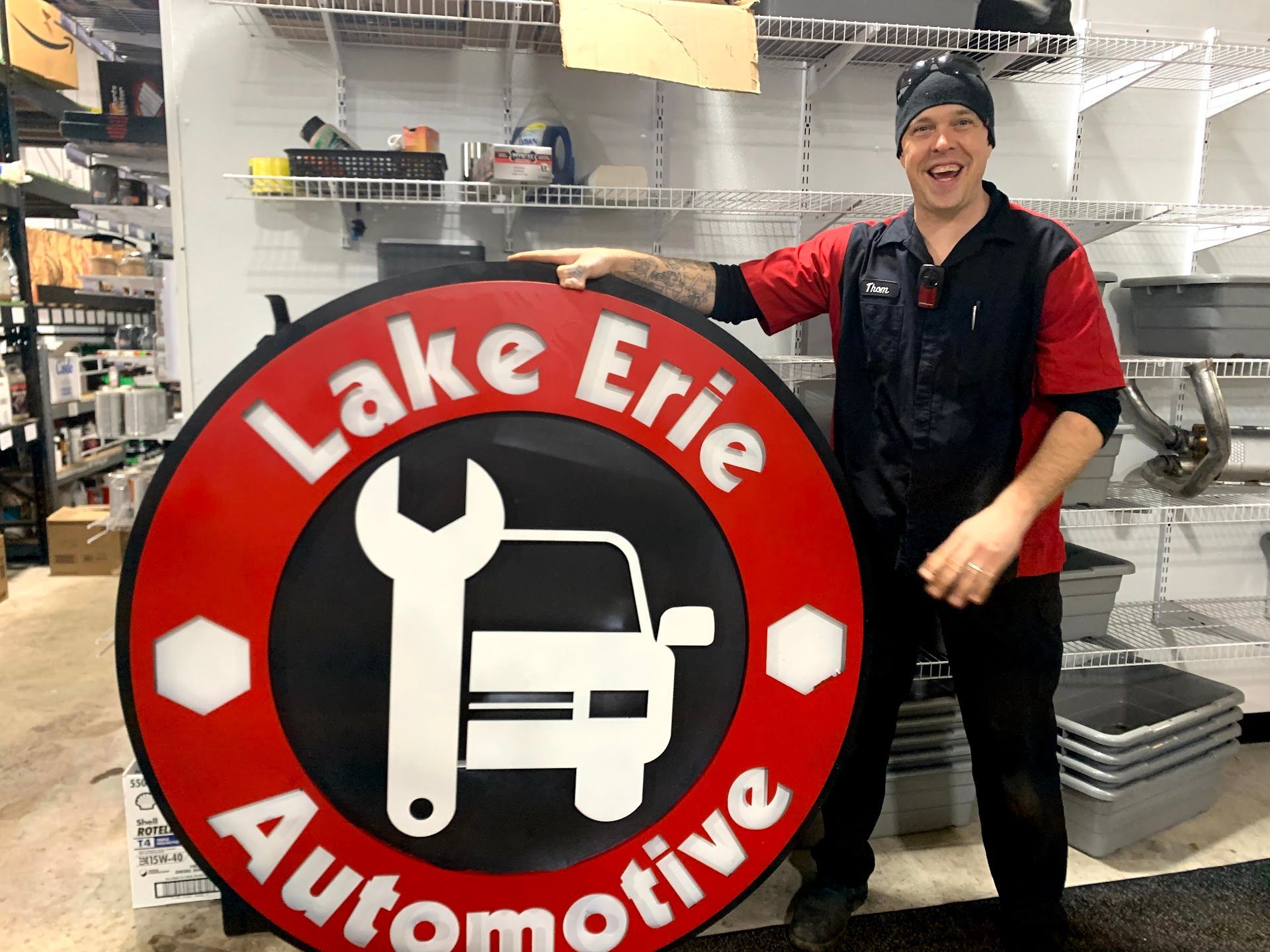 Technician Holding Large Lake Erie Automotive Shop Logo Sign | Lake Erie Automotive Service