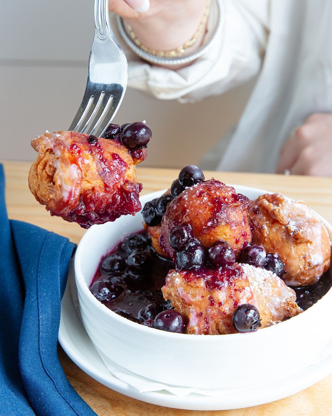 A person is holding a fork over a bowl of food