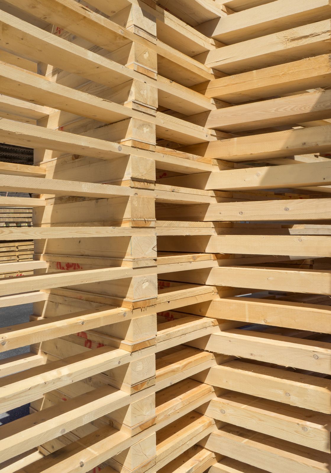 Stack of wooden pallets, viewed at an angle with visible slats and supports.