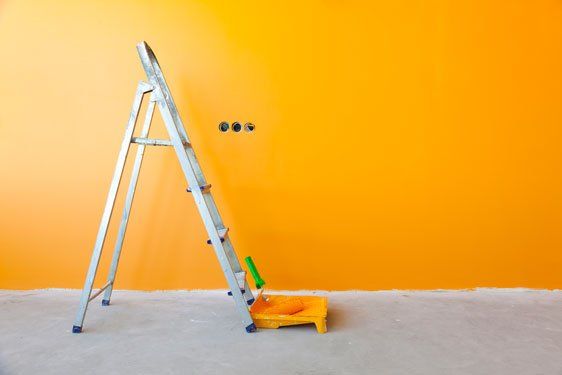 orange-painted wall with tools and materials for painting