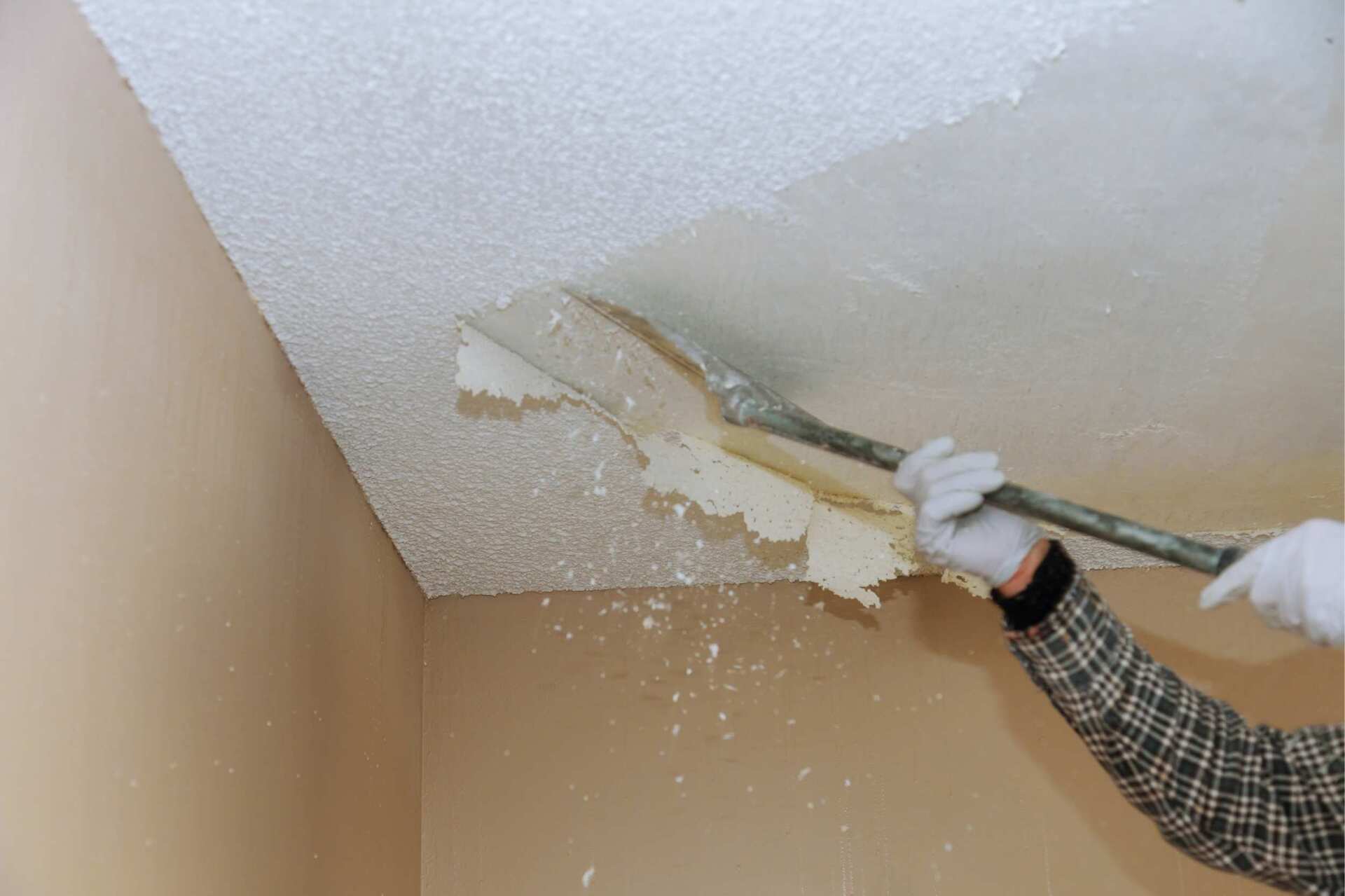 local contractor removing popcorn ceiling with a scraper