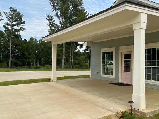 A house with a porch and a pink door