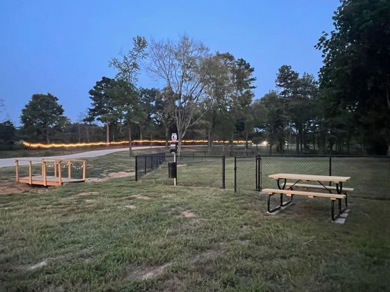 A picnic table is sitting in the middle of a grassy field.