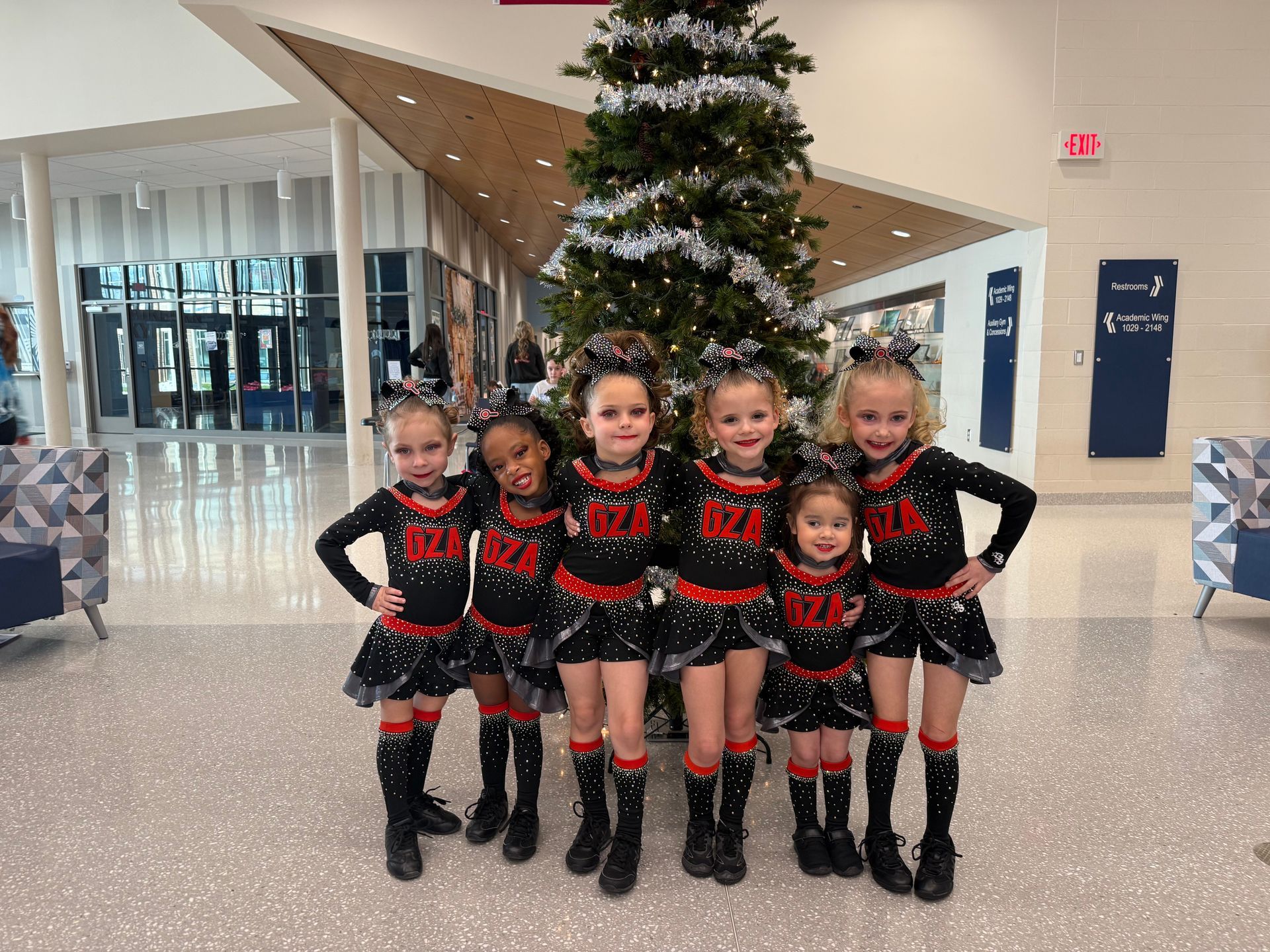 A group of cheerleaders are posing for a picture in front of a sign that says ground.