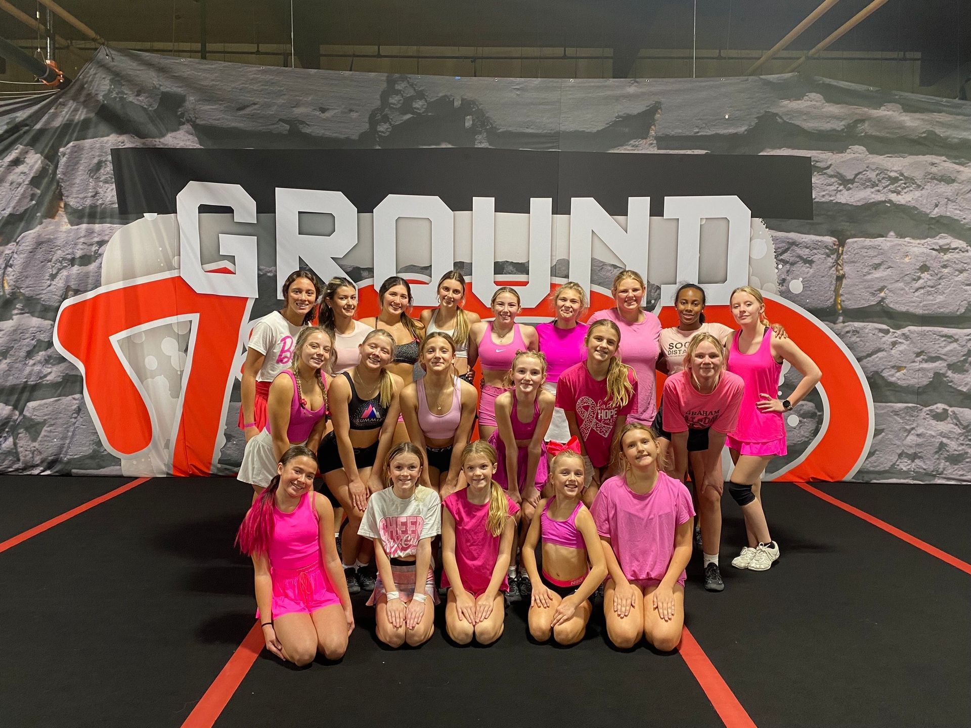 A group of young girls are posing for a picture in front of a sign that says ground 7.