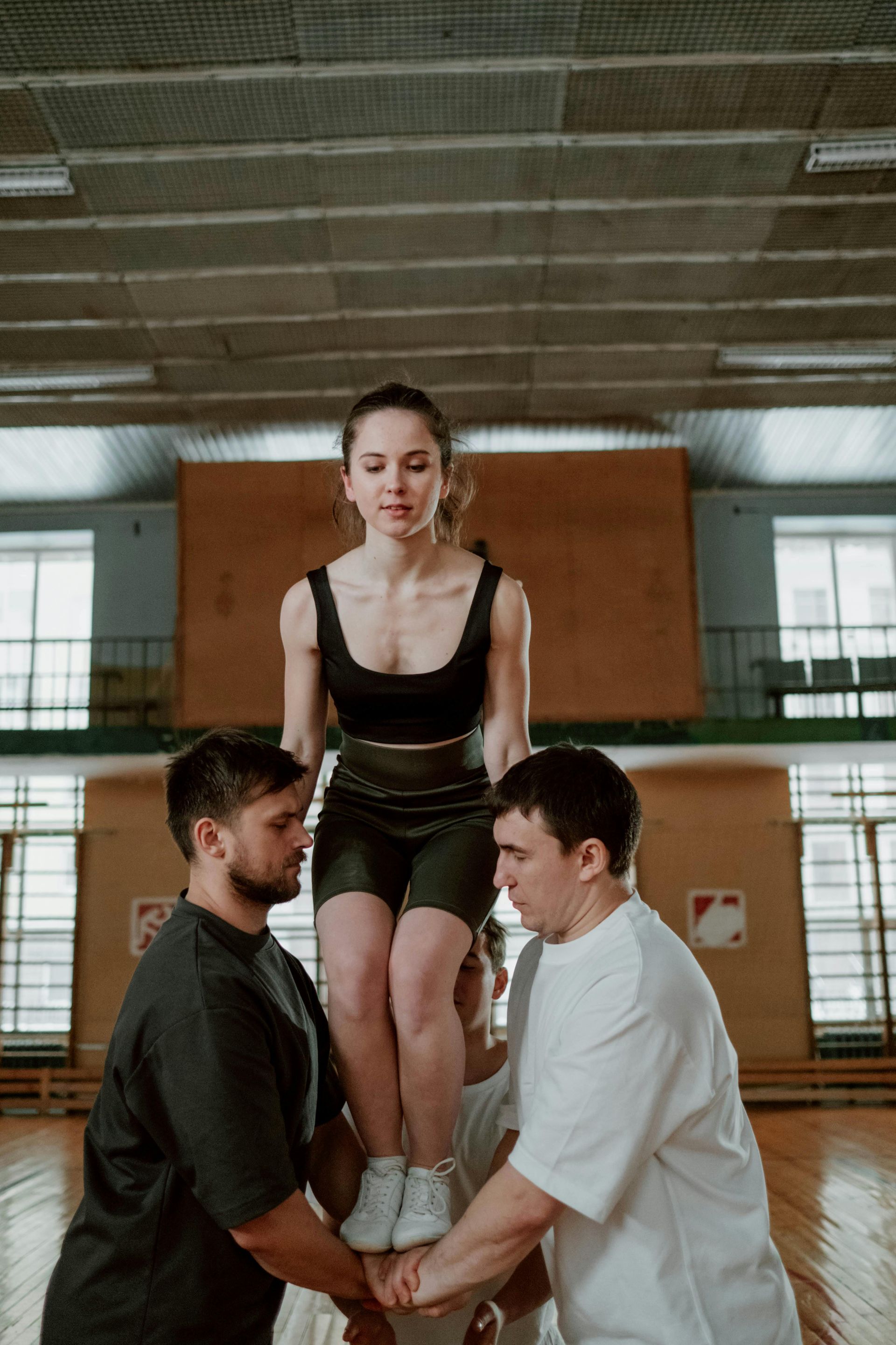 A man is carrying a woman on his shoulders in a gym.