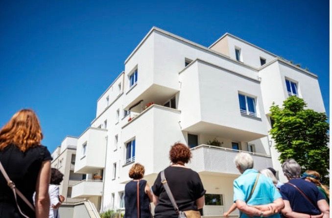 Several people looking at a home in a busy real estate market