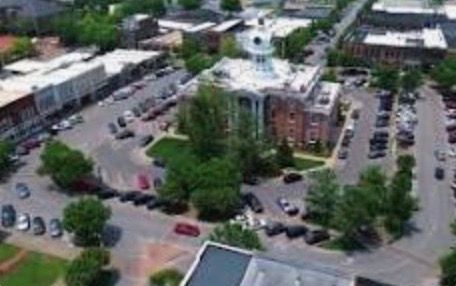 An aerial view of a small town with a courthouse in the middle of it.