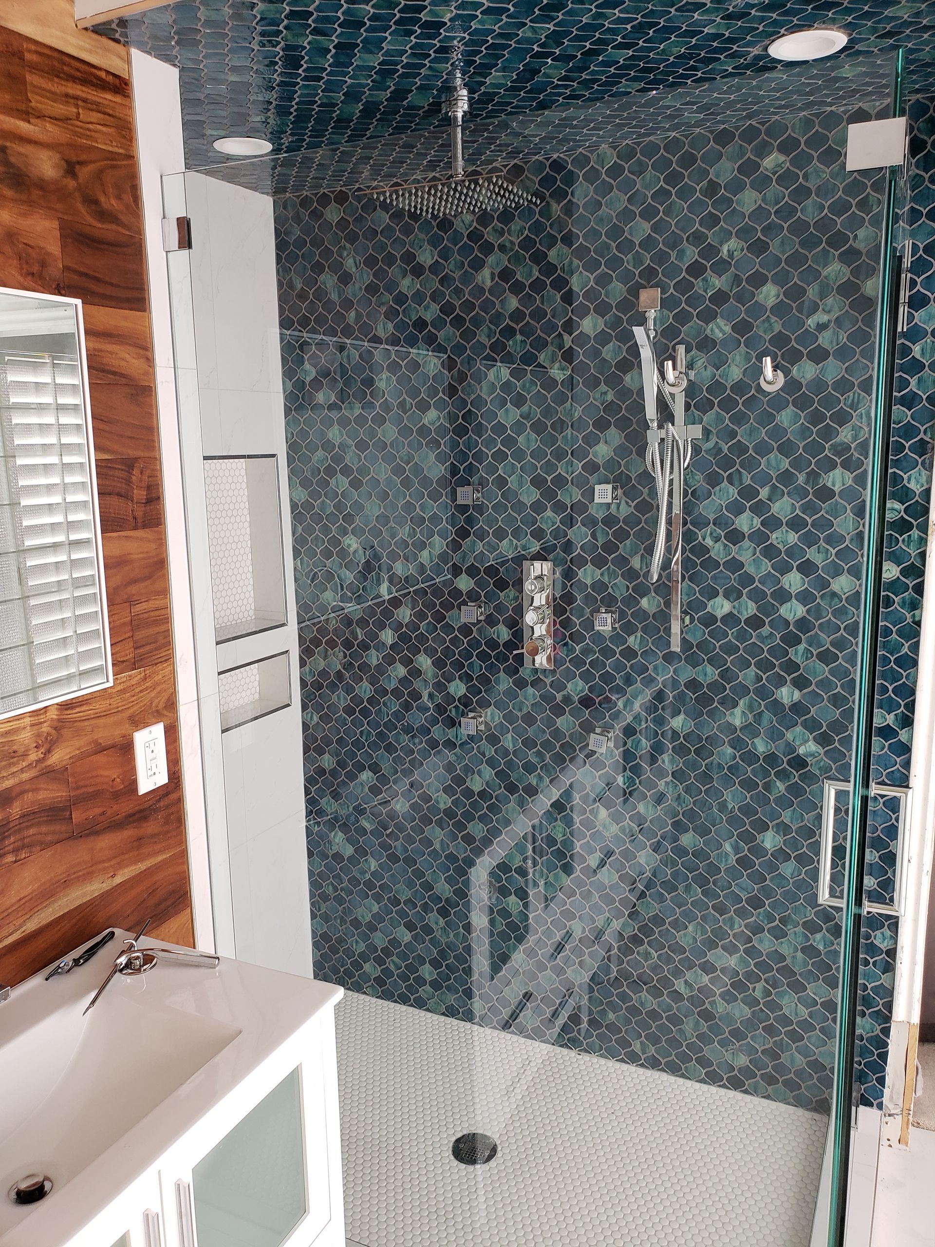 A bathroom with a walk in shower and a sink.