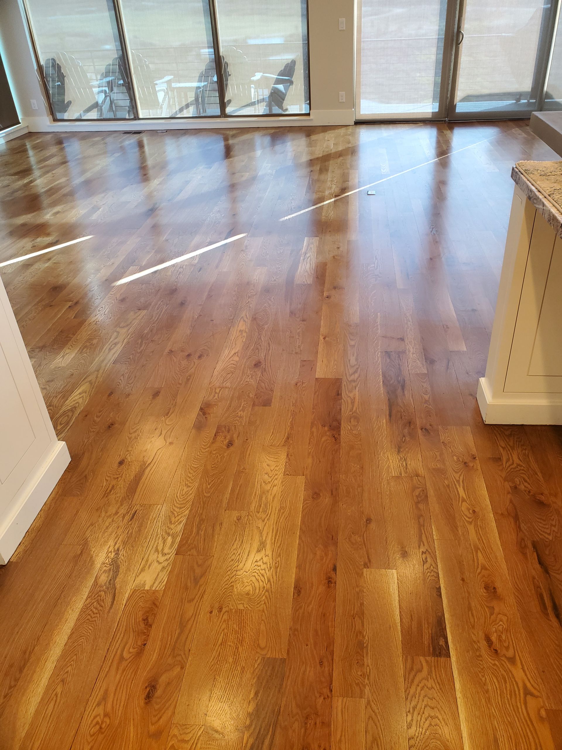 A kitchen with hardwood floors and a large window.