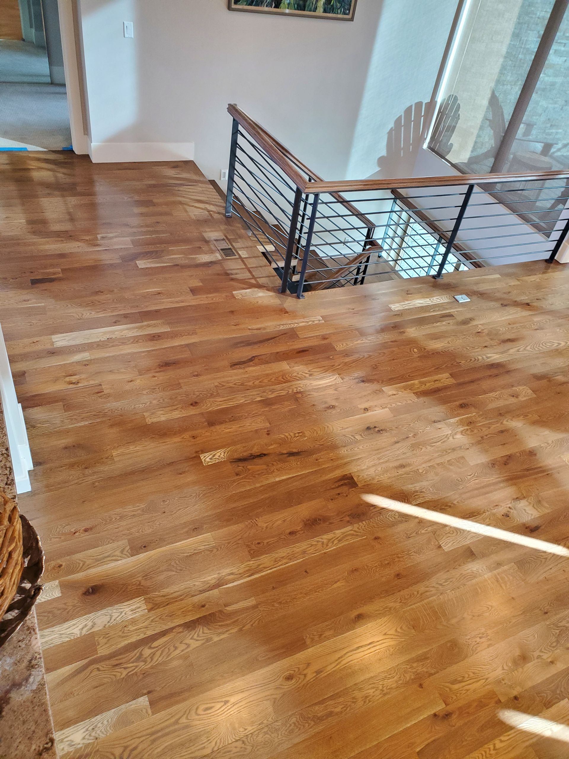 A wooden floor with a staircase in the background.