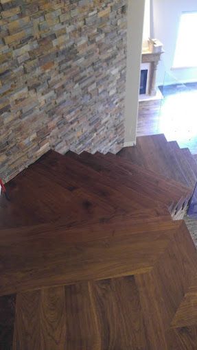 A wooden staircase with a stone wall in the background.