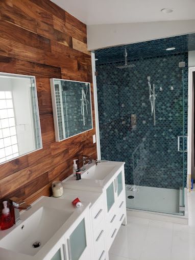 A bathroom with two sinks and a walk in shower.