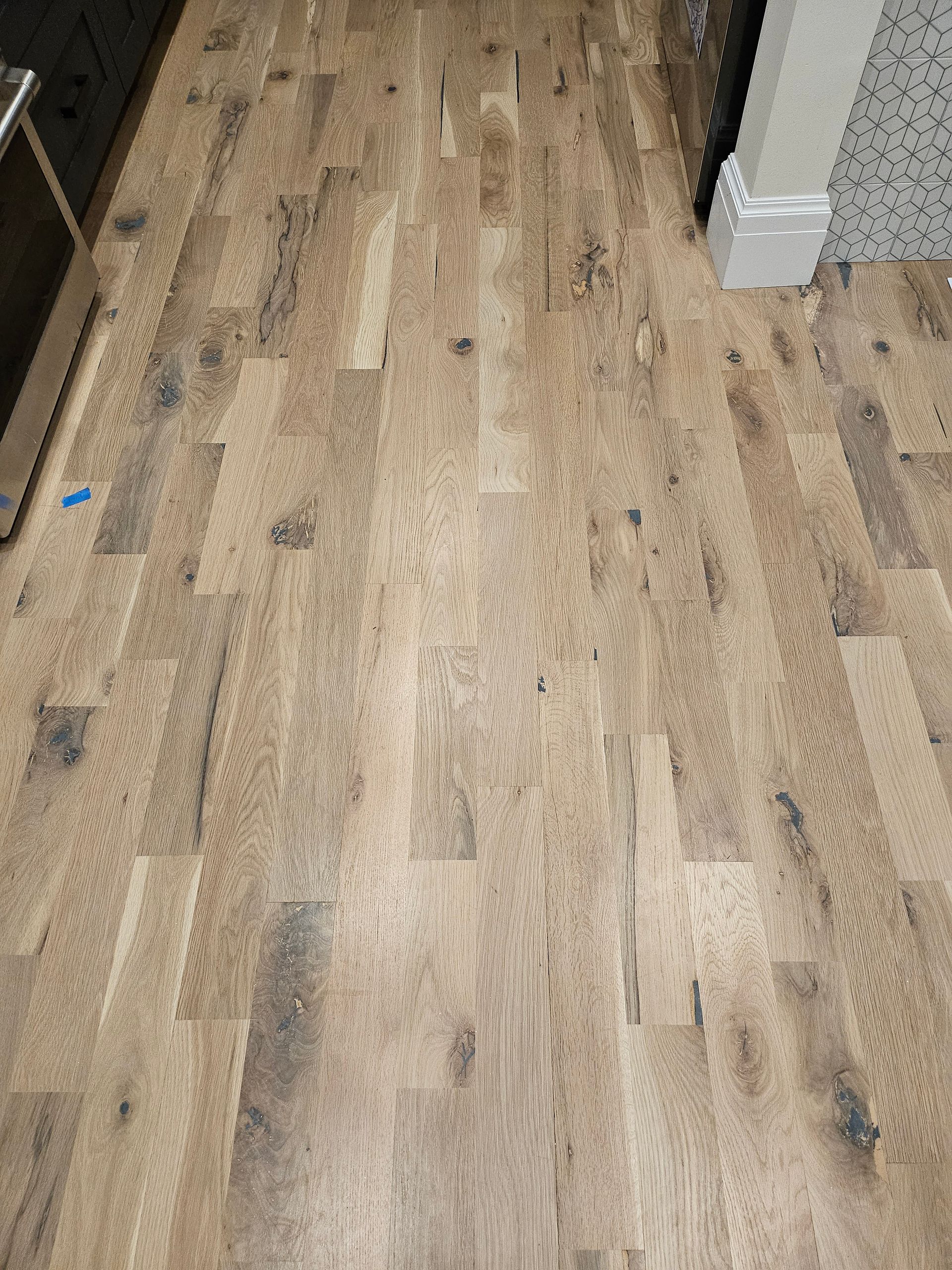 A close up of a wooden floor in a kitchen.