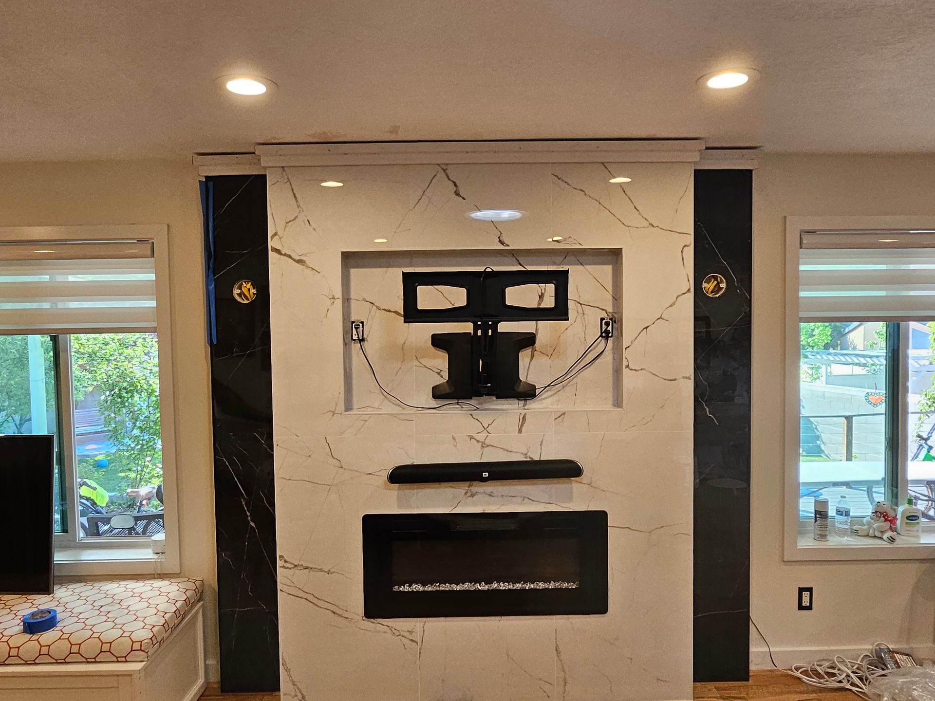 A living room with a fireplace and a flat screen tv mounted on the wall.