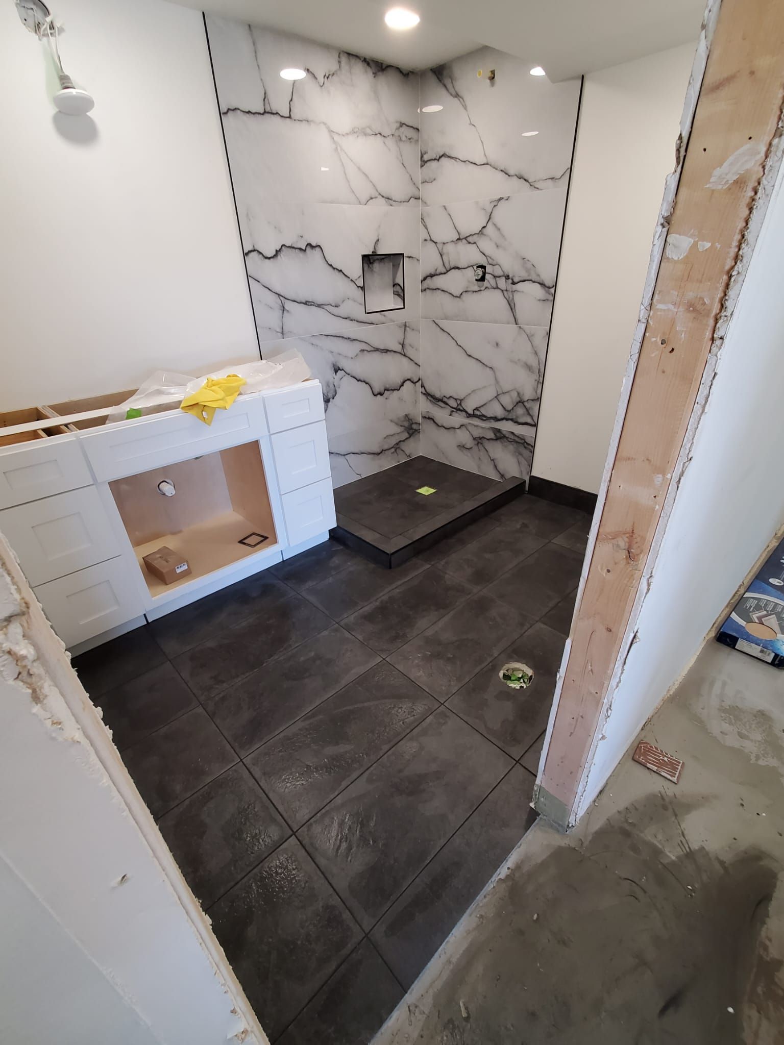 A bathroom under construction with a walk in shower.