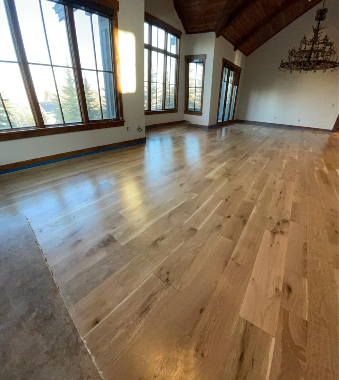 A large empty room with hardwood floors and lots of windows
