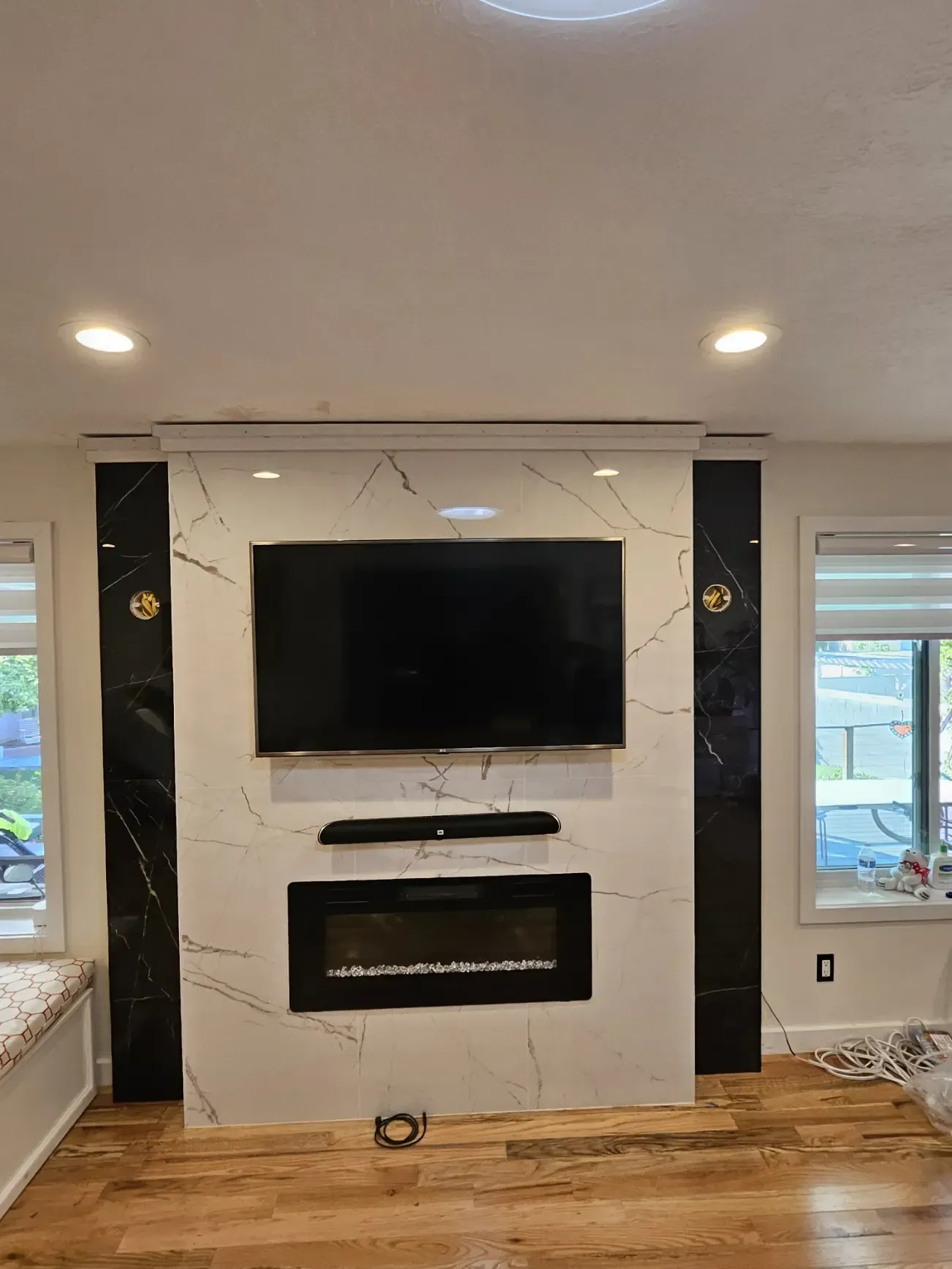 A living room with a fireplace and a flat screen tv on the wall.