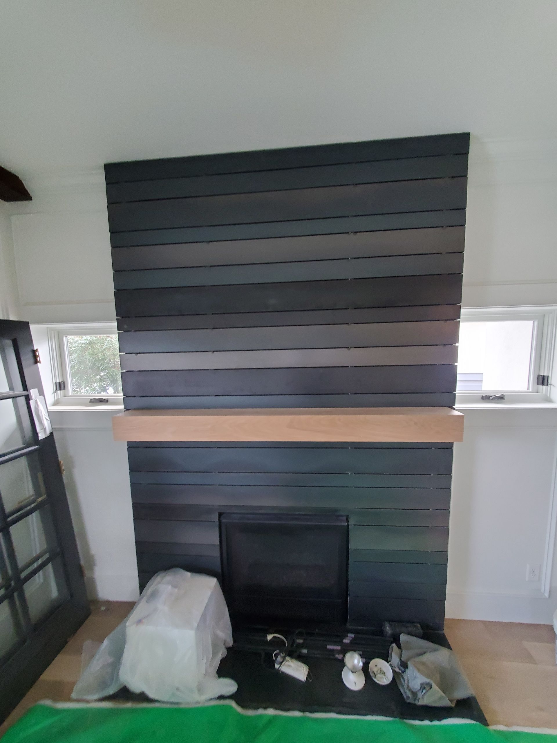 A fireplace with a wooden mantle in a living room.