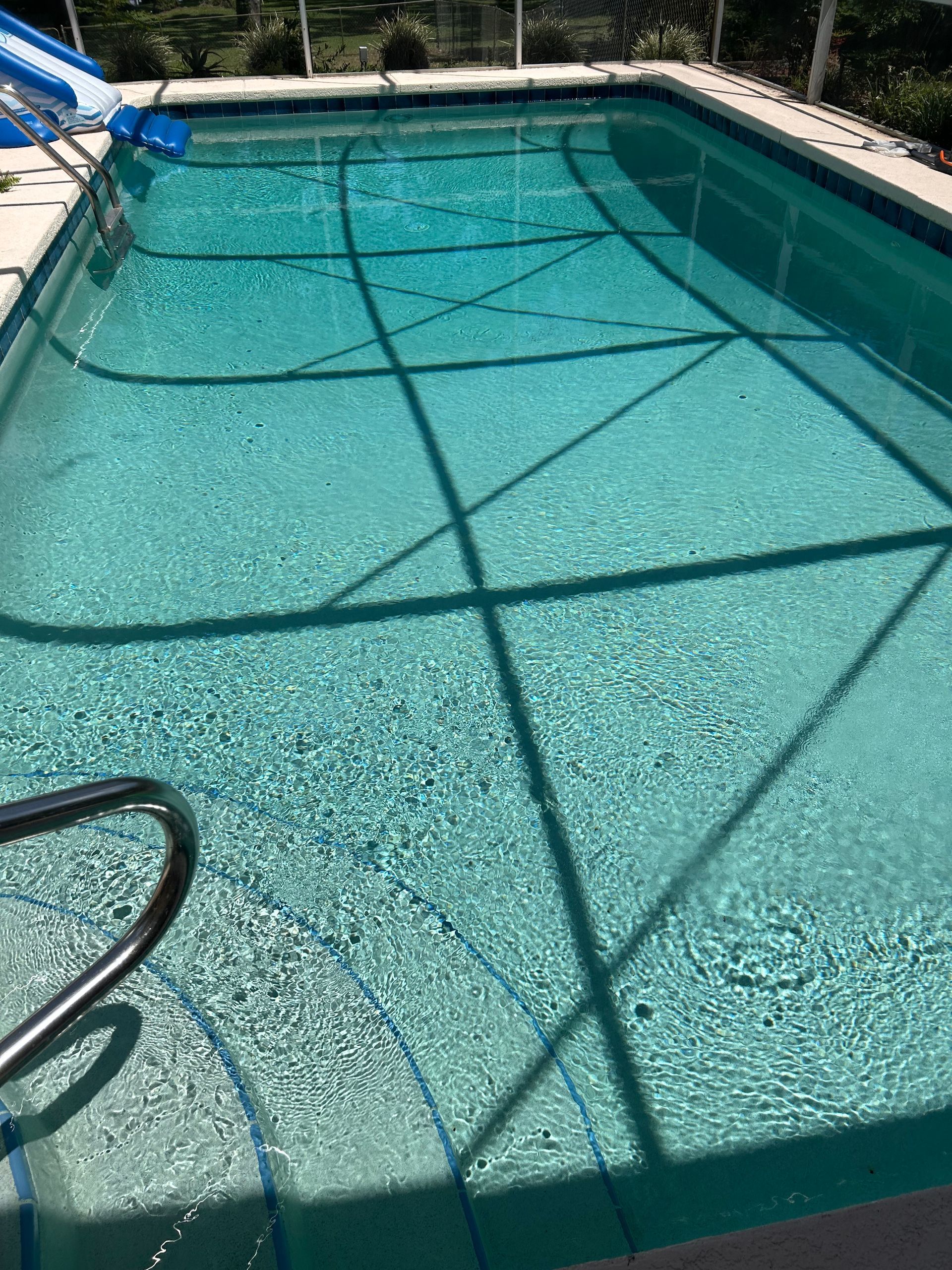 A large swimming pool with a slide in the background.