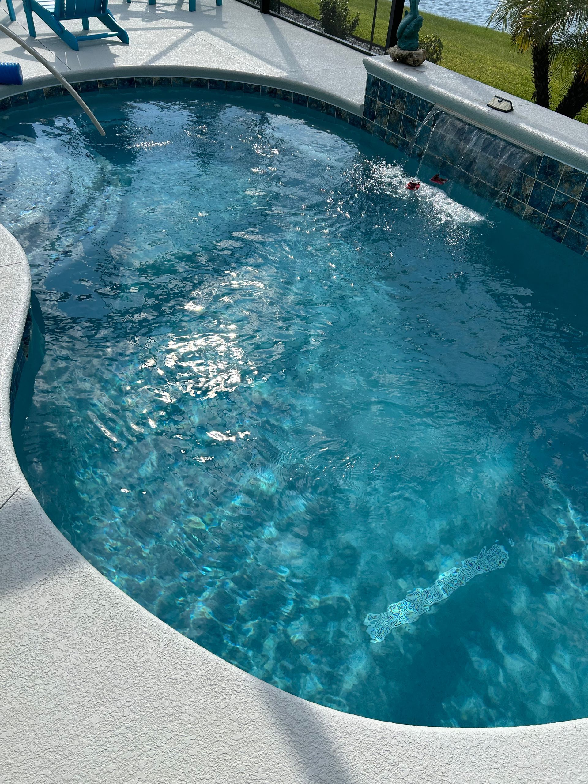 A person is swimming in a large swimming pool.