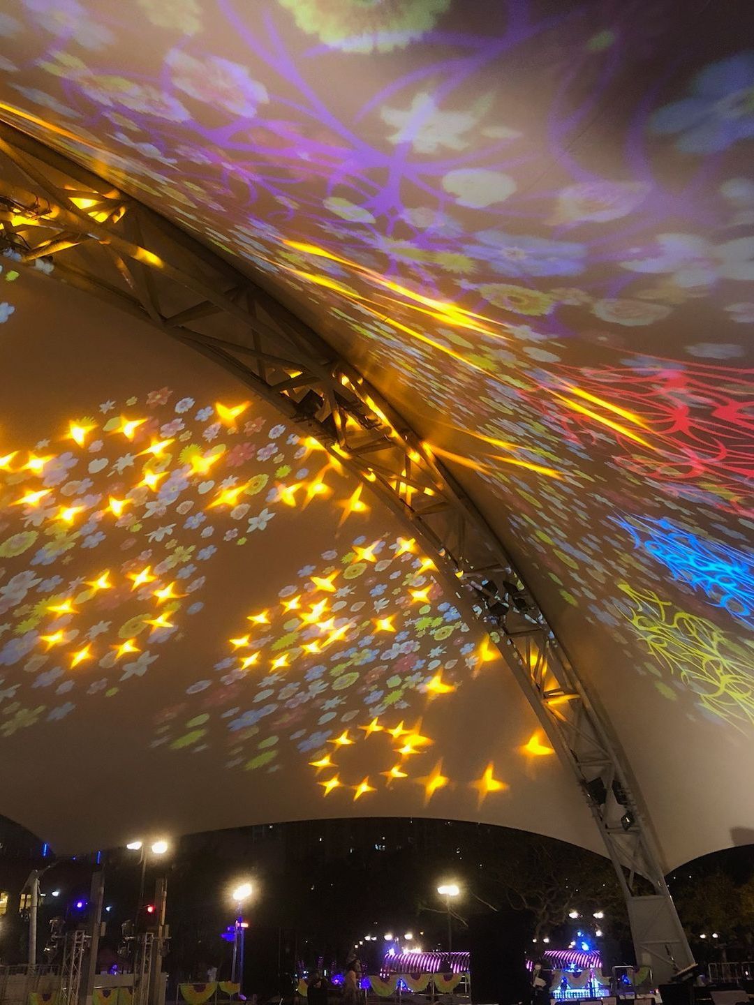 A tent with a lot of lights projected on it at night.