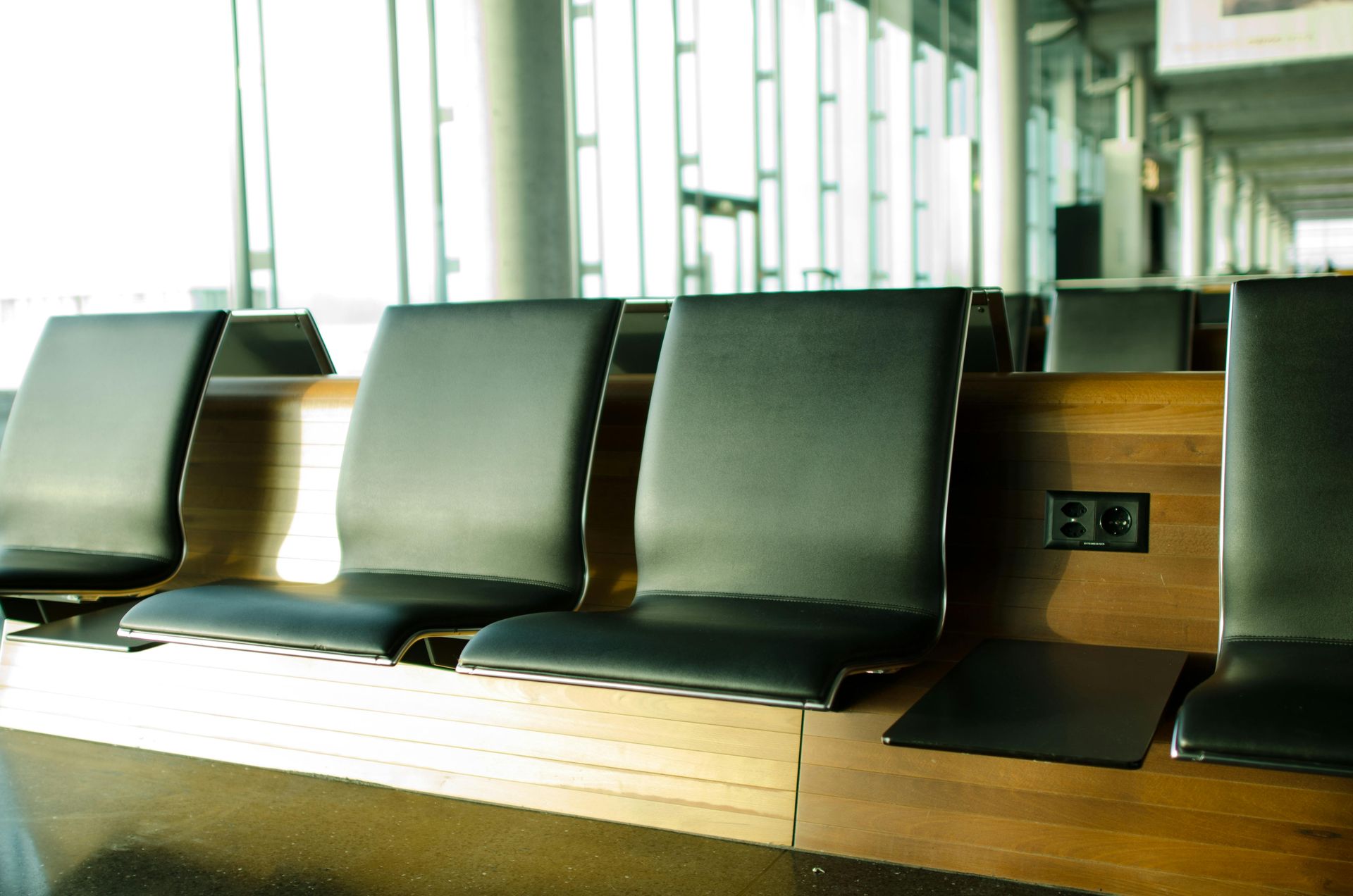 A row of black chairs in an airport waiting area
