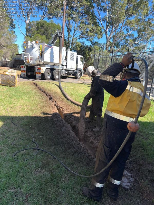 A blue truck is parked in a parking lot next to a traffic cone.
