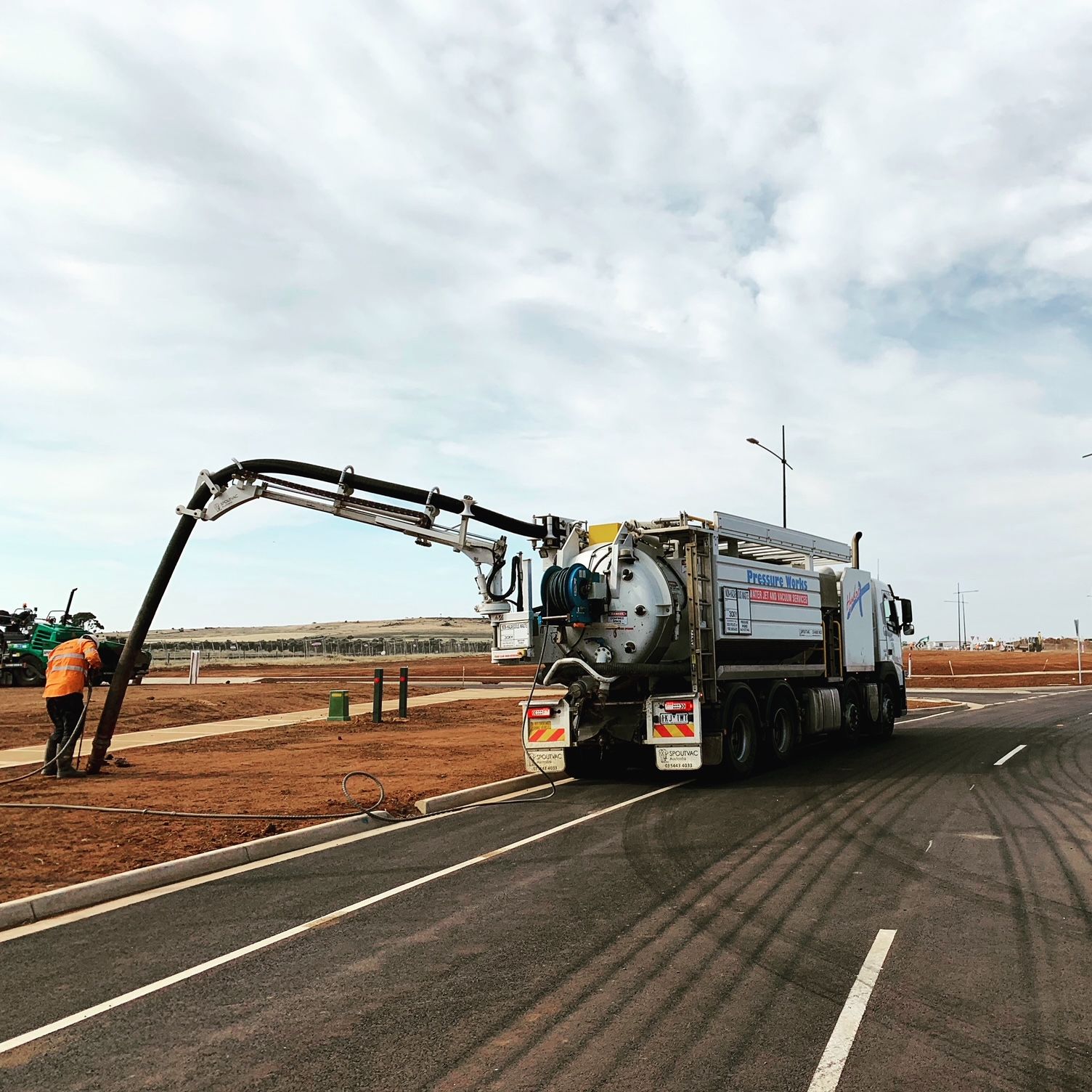A vacuum truck is driving down a road.