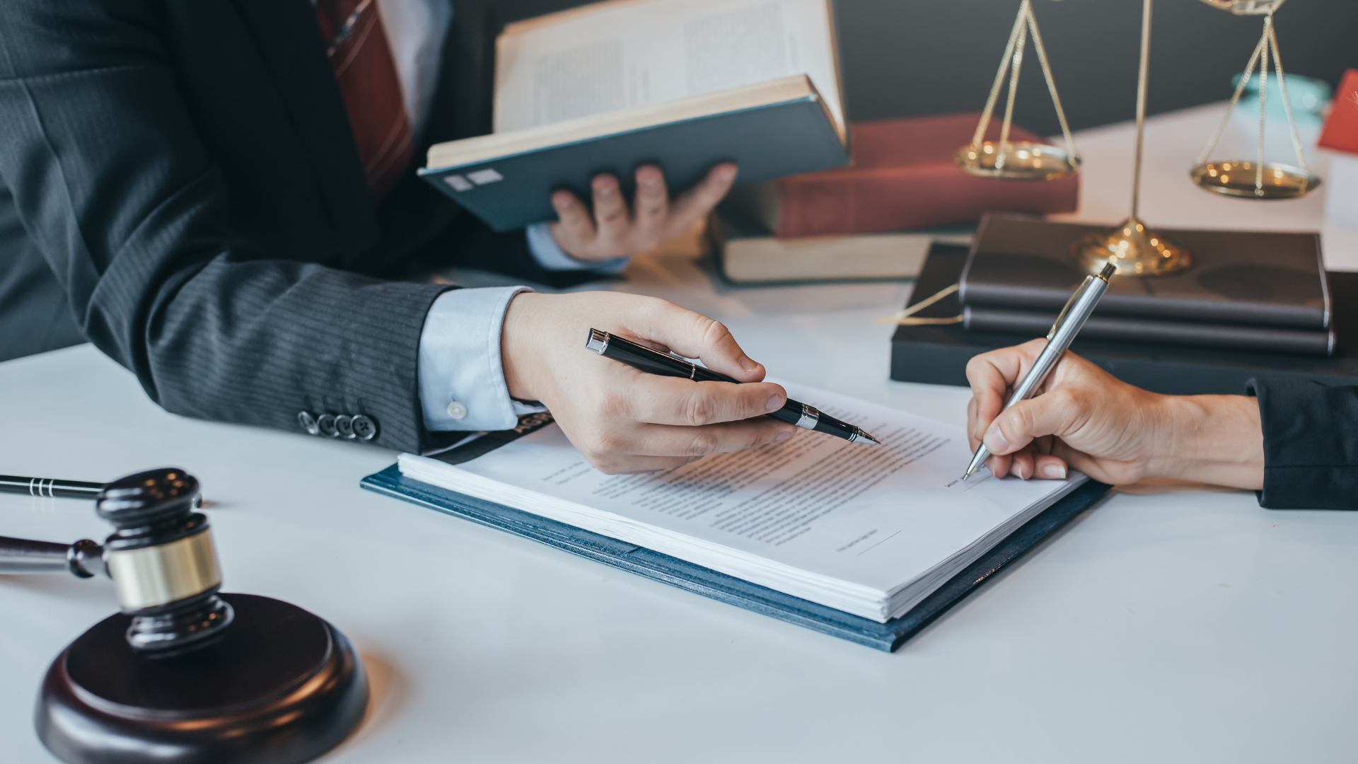 a man and a woman are sitting at a table signing a document .