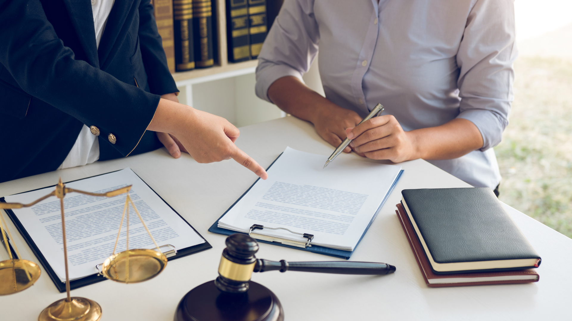 a man and a woman are sitting at a table with papers and a gavel .