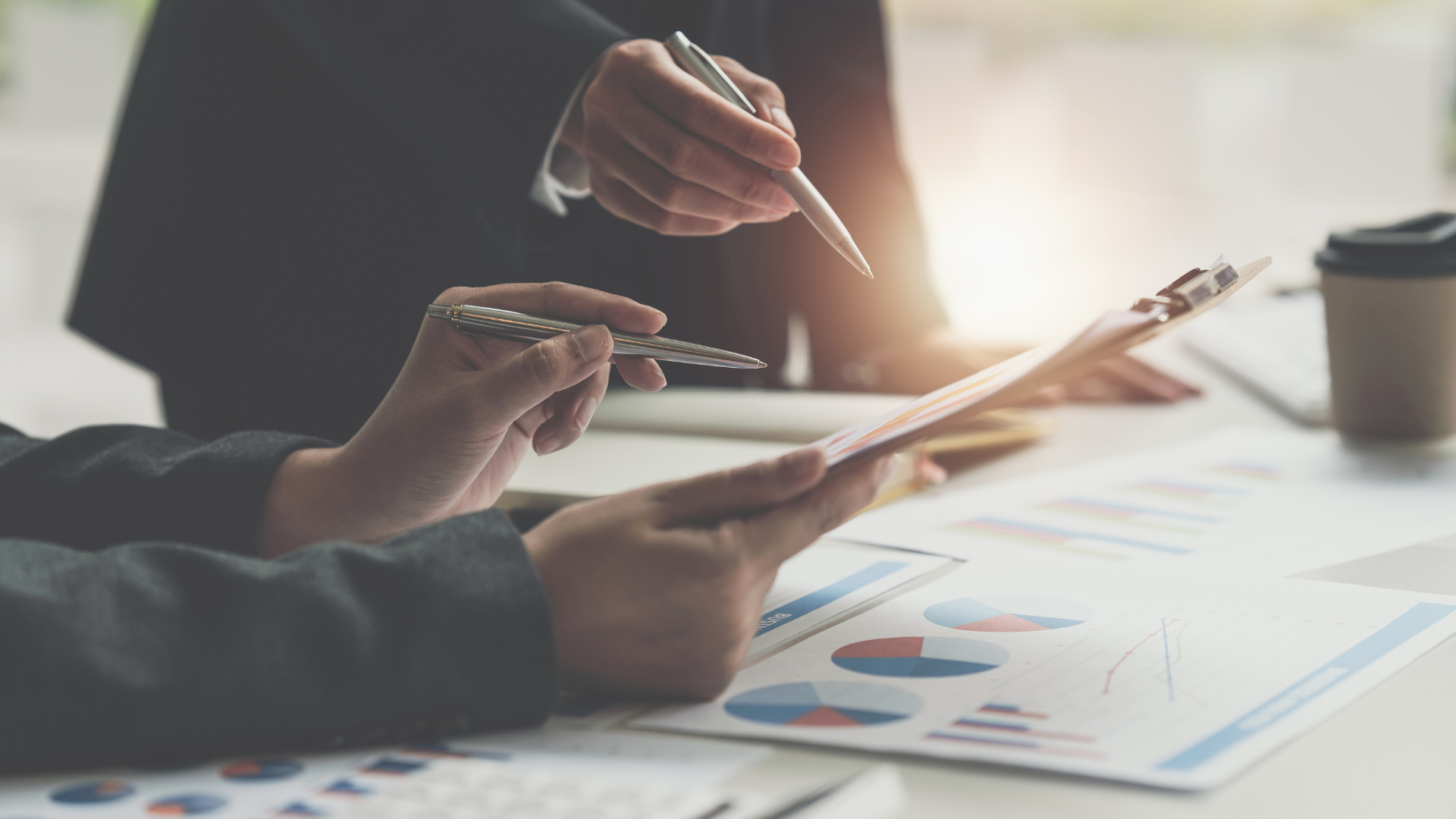 a group of people are sitting at a table looking at a piece of paper .