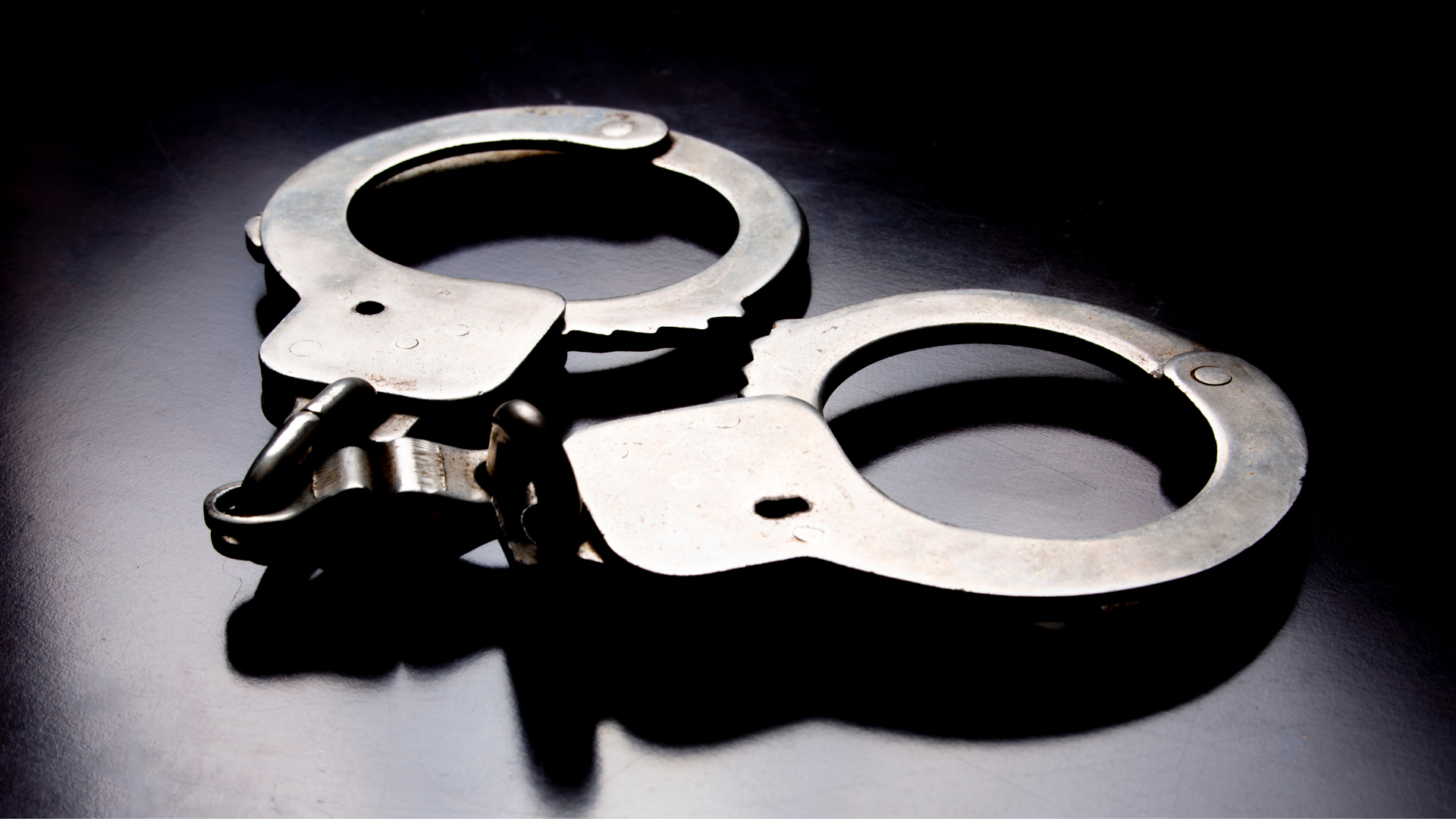 a pair of handcuffs on a black surface