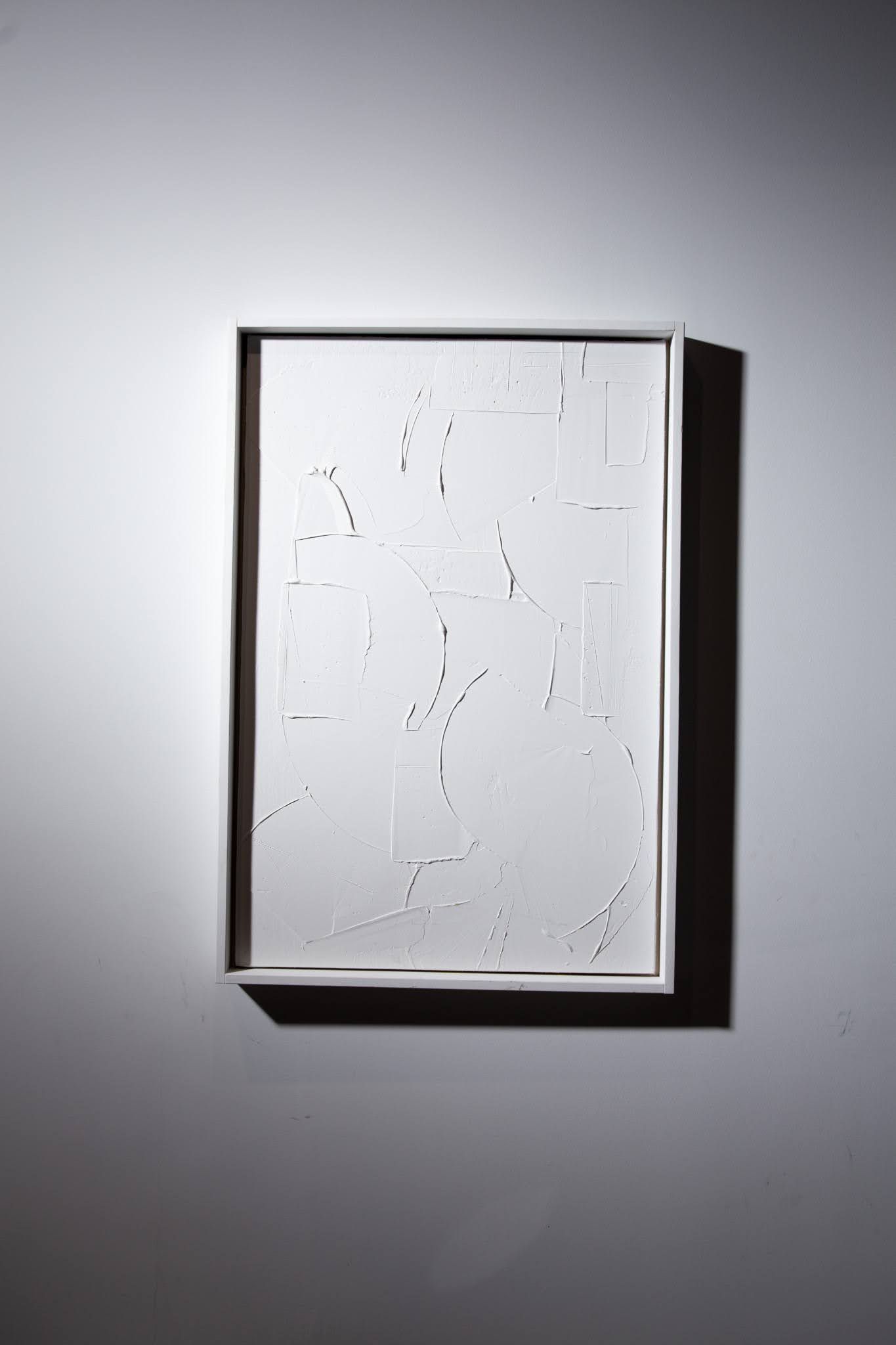 White framed artwork on a white wall. Contains what appears to be Braille dots, with strong shadows; art by Matt Remsbecher. 