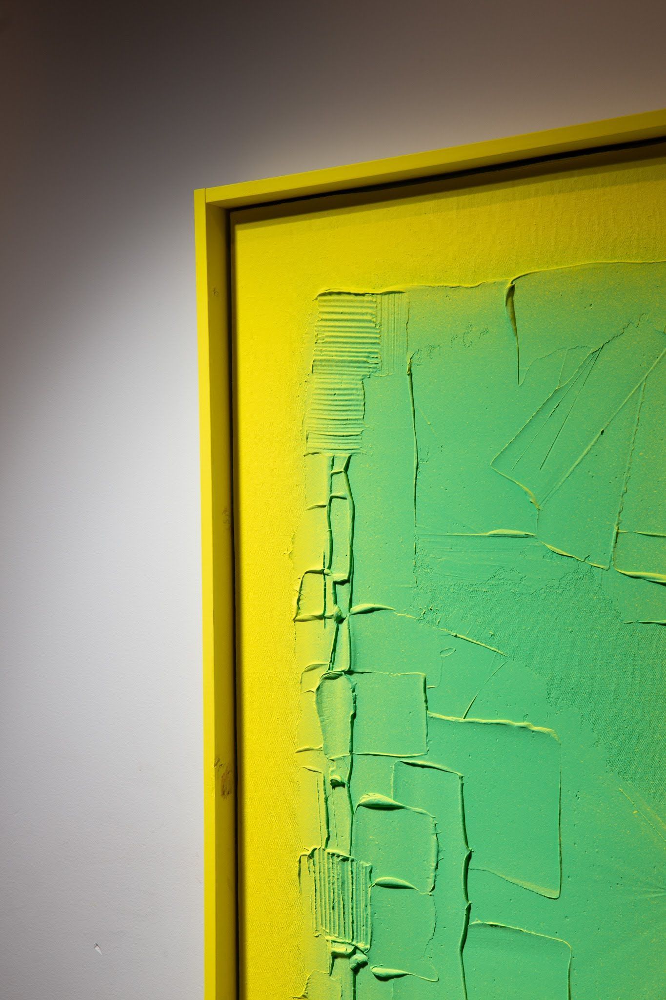 Yellow-framed abstract art with a green, textured surface; art by Matt Remsbecher. 